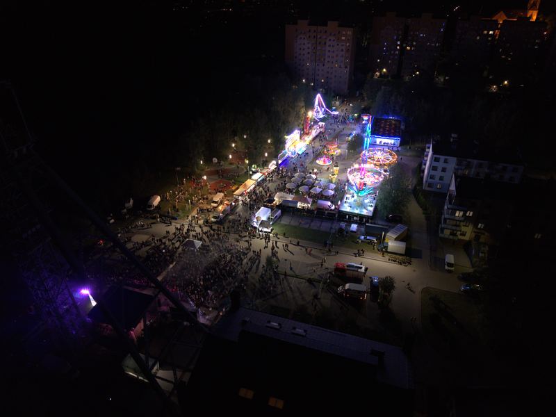 Teren imprezy i szyb kopalni nocą, w tle światła całego miasta