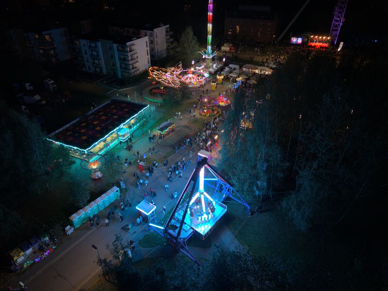 Rozświetlone karuzele i wieża swobodnego spadania widziane z góry nocą